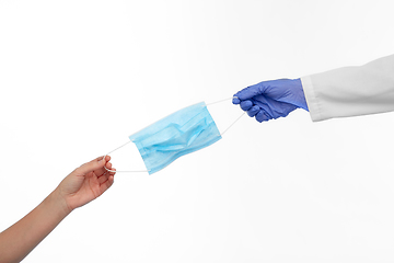 Image showing hand of doctor giving medical mask to patient