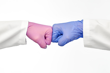 Image showing hands of doctors in gloves make fist bump gesture