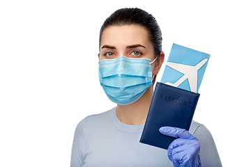 Image showing young woman in mask with air ticket and passport