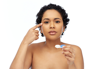 Image showing african american woman putting on contact lenses