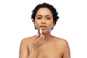 Image showing african american woman applying lipstick