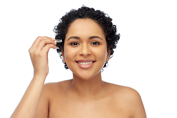 Image showing african woman with tweezers tweezing her eyebrow