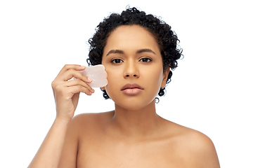 Image showing young woman massaging her face with gua sha tool