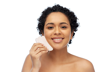 Image showing happy woman massaging her face with gua sha tool