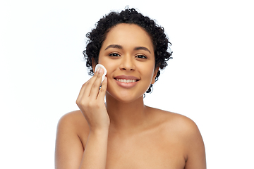 Image showing happy african woman cleaning face with cotton pad