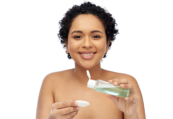 Image showing happy african woman with cotton pad an lotion