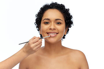 Image showing happy woman and hand of make up artist with brush