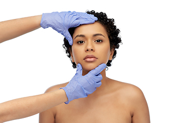 Image showing face of african woman and hands in medical gloves