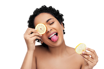 Image showing african american woman making eye mask of lemons