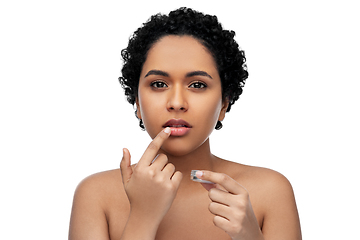 Image showing african american woman applying lip gloss