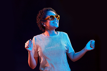 Image showing african american woman dancing over neon lights