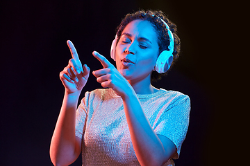 Image showing woman in headphones listening to music and dancing