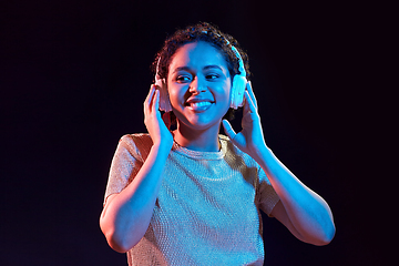 Image showing woman in headphones listening to music and dancing