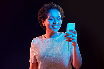 Image showing african woman with smartphone in neon lights