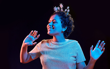 Image showing african woman in party cap with blower over black