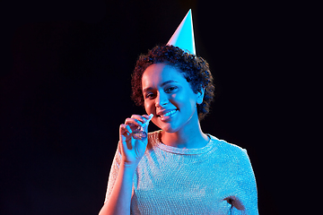 Image showing african woman in party cap with blower over black