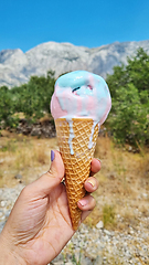 Image showing Melting gelato ice cream cone held up to the hot summer day