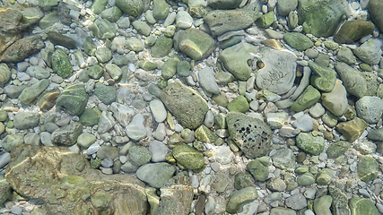 Image showing Blurred abstract marine background, stones underwater. Clear sea water covers the rocks