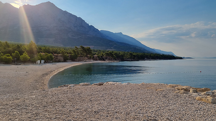 Image showing Beautiful shore of the Adriatic Sea. Sunrise over Biokovo Mountain Nature park and trees from Makarska Riviera-Biokovo, Dalmatia, Croatia, Europe