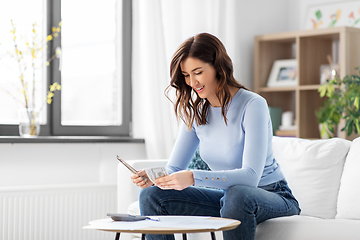 Image showing happy woman counting money at home