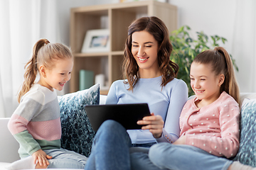 Image showing happy mother and daughters with tablet pc at home