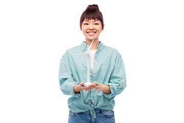 Image showing smiling young asian woman with toy wind turbine