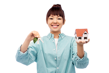 Image showing smiling asian woman holding house model and keys