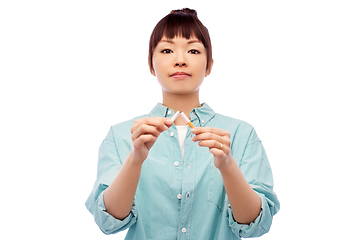 Image showing asian woman braking cigarette over white background