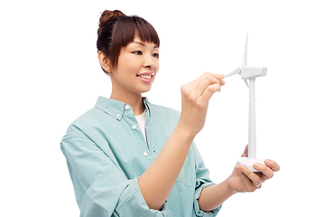 Image showing smiling young asian woman with toy wind turbine