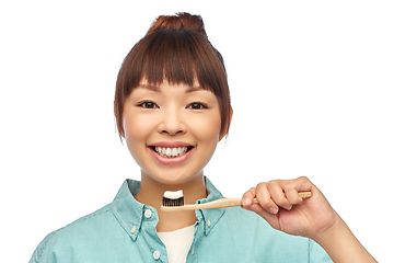 Image showing asian woman with toothpaste on wooden toothbrush