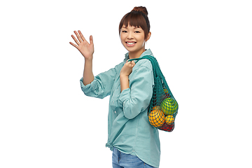 Image showing happy asian woman with food in reusable string bag