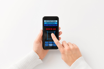 Image showing hand holding phone with certificate of vaccination