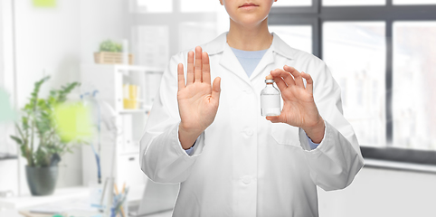 Image showing doctor with syringe shows stop gesture at hospital