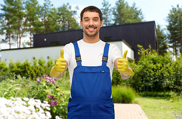 Image showing happy male worker or cleaner in gloves at garden