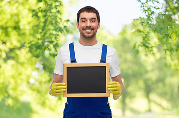 Image showing smiling worker or male cleaner showing chalkboard