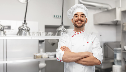 Image showing happy smiling male chef in toque at kitchen