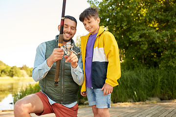 Image showing happy smiling father and son fishing on river