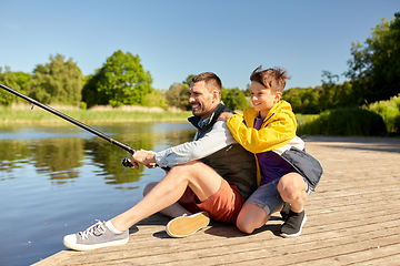 Image showing happy smiling father and son fishing on river