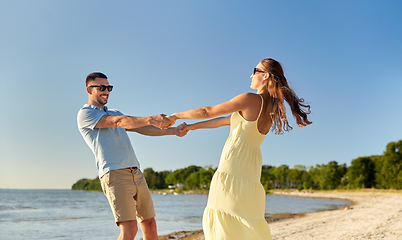 Image showing happy couple holding hands on summer beach