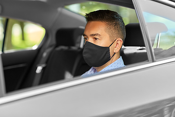 Image showing man or male passenger wearing black mask in car