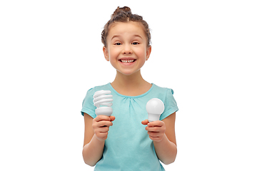 Image showing smiling girl comparing different light bulbs