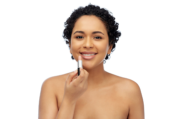 Image showing african american woman applying lipstick