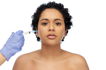 Image showing face of african woman and hand with syringe