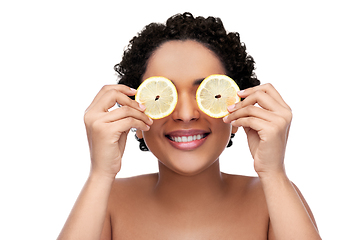 Image showing african american woman making eye mask of lemons