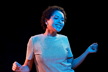 Image showing african american woman dancing over neon lights