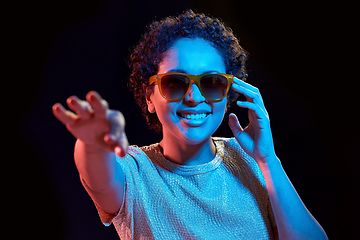 Image showing african woman in sunglasses over neon lights