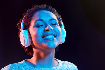 Image showing woman in headphones listening to music and dancing
