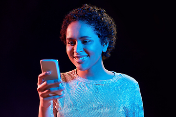 Image showing african woman with smartphone in neon lights