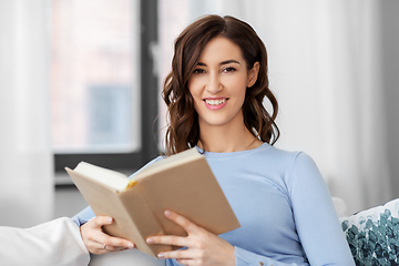 Image showing young woman reading book at home