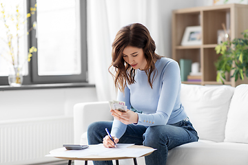 Image showing happy woman counting money at home